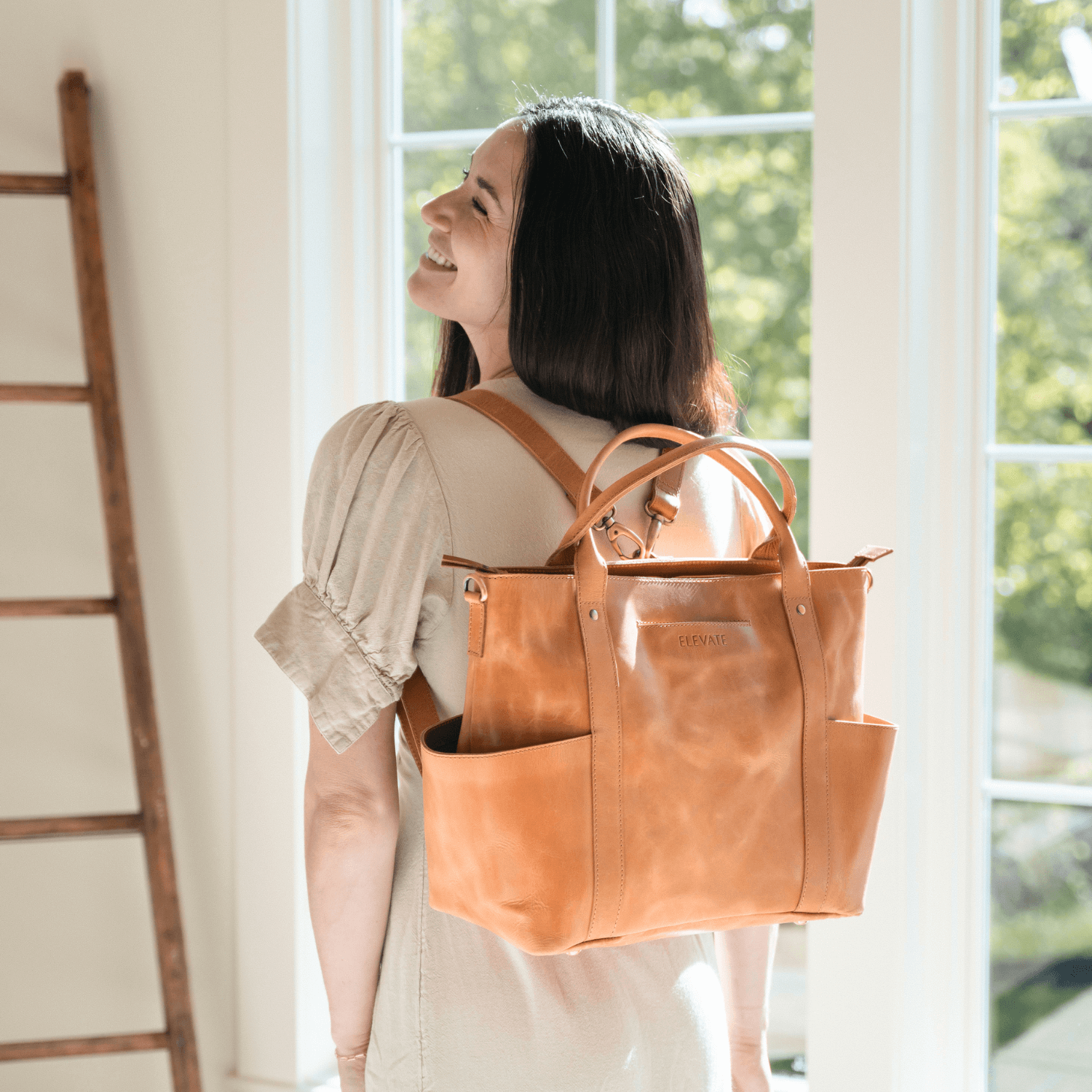 Woman standing in Living Room wearing Utility Tote as a backpack