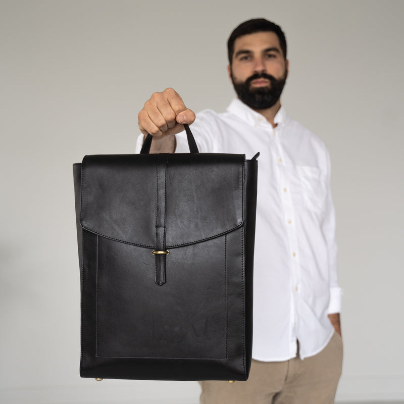 Man holding the Atlas leather backpack from Elevate